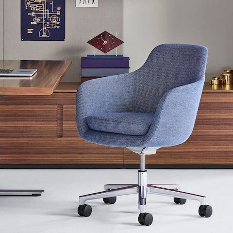 A private office featuring a mid-back Saiba office chair with light blue upholstery, a height-adjustable base, and casters.