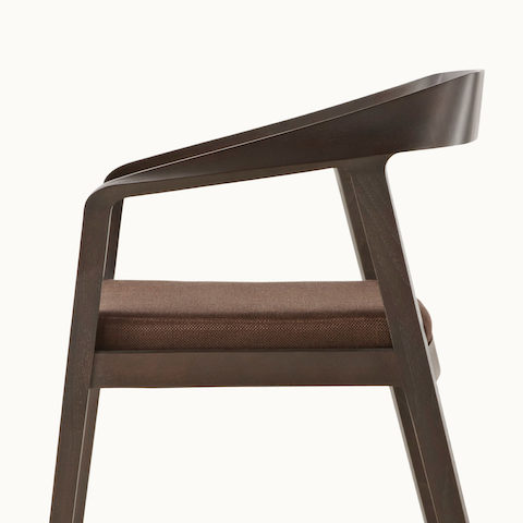 Side view of a Full Twist Guest Chair, showing the ribbon-like piece of wood that forms the sculpted arms and backrest.