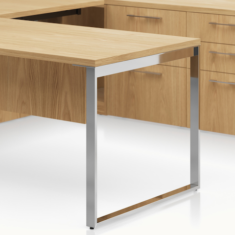 Detail shot of the Geiger One Casegoods loop leg option in chrome in a Natural Flat Cut Oak private office.