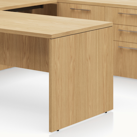 Detail shot of the Geiger One Casegoods fixed end panel leg option in Natural Flat Cut Oak.